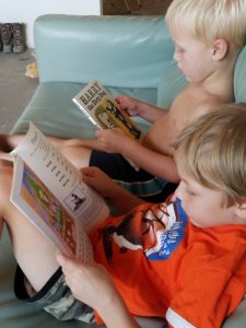 Two Brothers Reading on the Couch Together