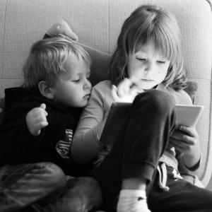 Two kids watching an electronic screen
