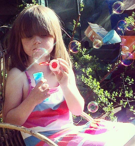 Exhausted girl blowing bubbles after school is over