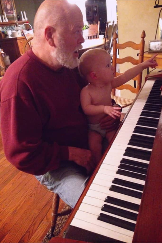 Grandfather teaching baby about music
