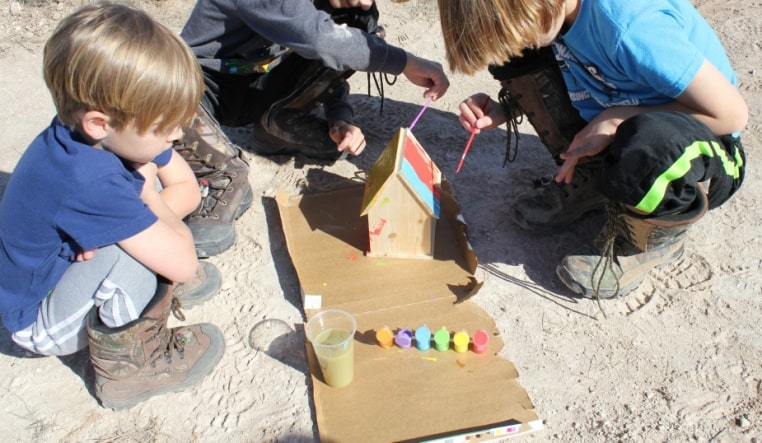 My children painting a bird house together