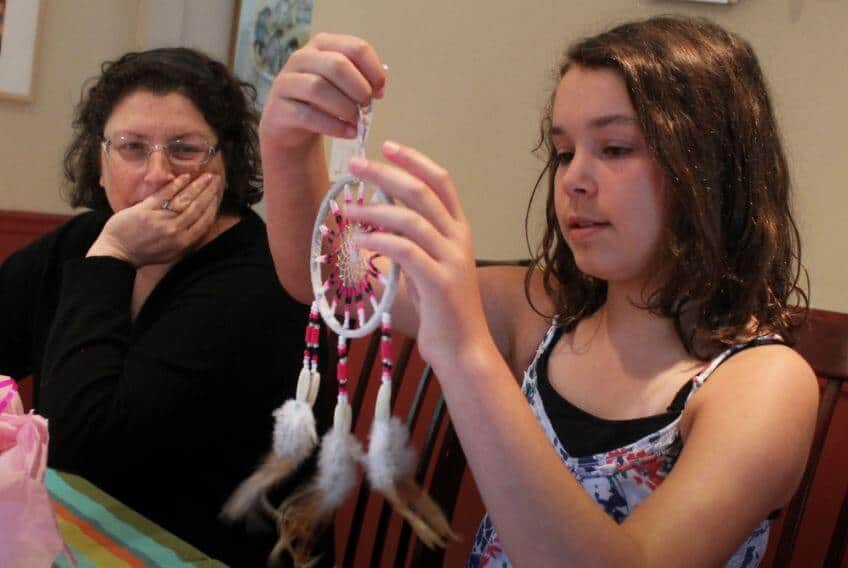 A 5th grader making a homemade Indian dream catcher