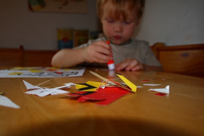 Child using a glue stick for creative crafts