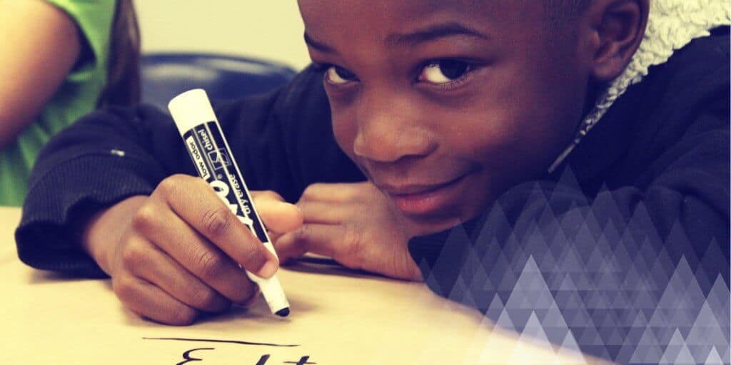 A young boy doing a math game with a dry erase marker