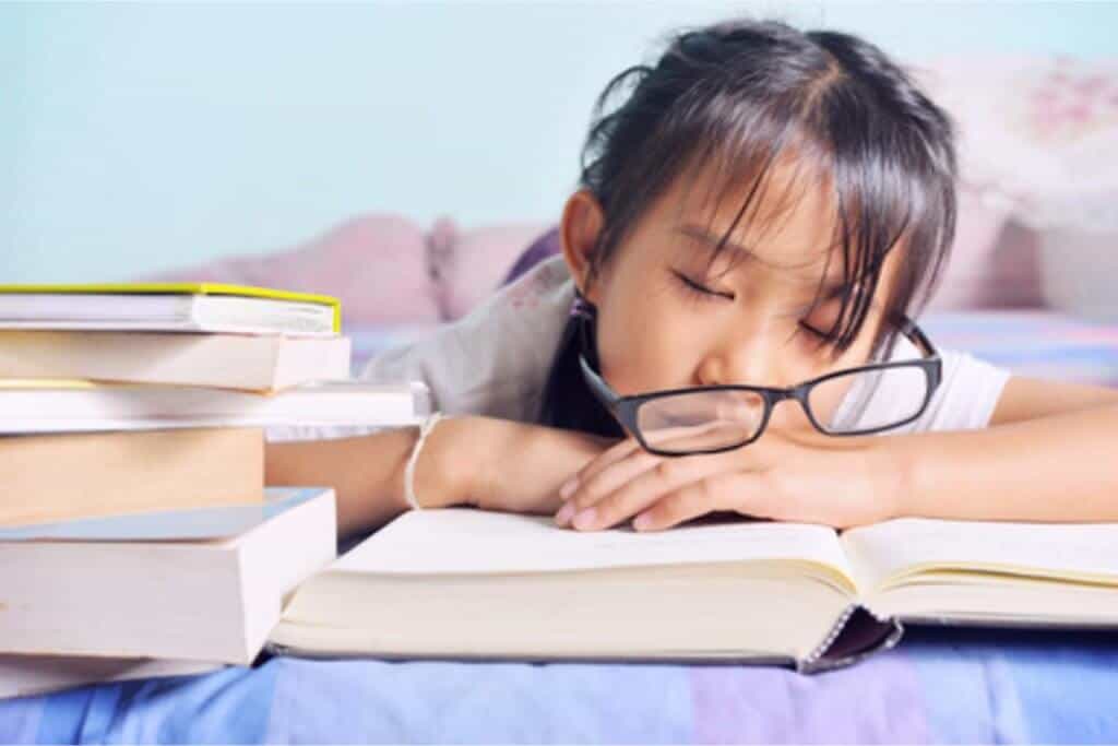 A girl falling asleep with glasses falling off her head