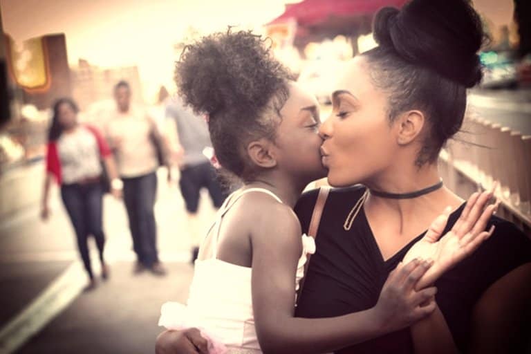 A mother kissing her daughter's cheek