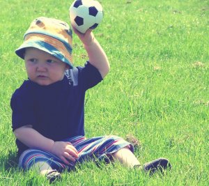 Boy holding a soccer ball in a field